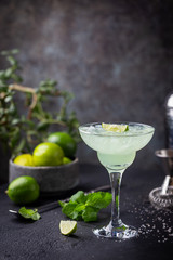 margarita cocktail with lime in a glass on dark background