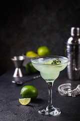 margarita cocktail with lime in a glass on dark background