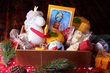 Gift Christmas box with soft toys (unicorn, hand-painted ball, apple, card) and handmade candles. Christmas decorations