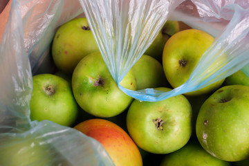 Group of ripe green organic apples in plastic bag, top view