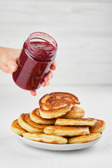 Delicious pancakes with raspberry jam on white background closeup