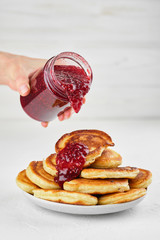 Delicious pancakes with raspberry jam on white background closeup