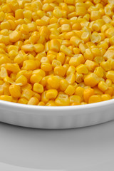 canned corn in white plate top view