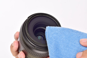 Cleaning camera lens with microfiber cloth on white background