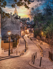 Street view of the Sacre Coeur Basilica at the summit of the butte Montmartre. Winding road in...