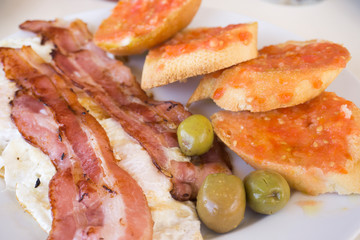 Bacon eggs bread with tomato and green olives Spain