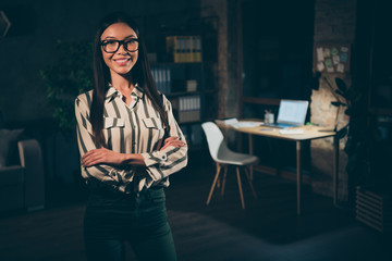 Make yourself at home. Photo of pretty asian business lady working late meeting colleagues partners crossed arms friendly atmosphere wear specs striped shirt dark modern office