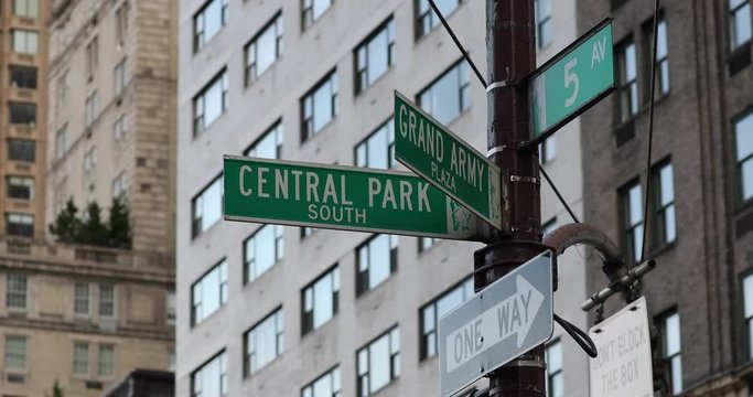 Central Park South and Grand Army Plaza street signs crossing with fifth avenue in Manhattan, New York