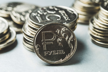 Russian ruble on the background of a stack of five-ruble coins, close-up, the concept of growth of the Russian economy
