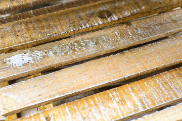 Old rustic wooden boards made of wood, vintage shabby background with partially damaged shattered strokes of white paint.