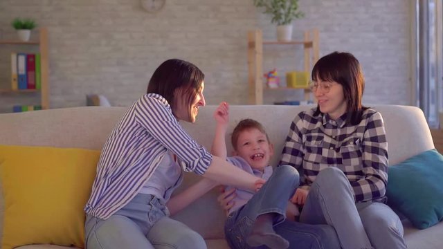 happy family two young femals and little son on the couch