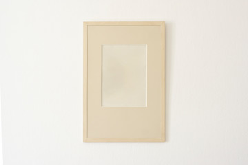 Empty simple photo frame on white wall