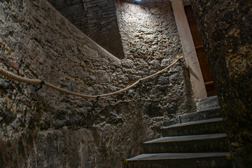 Spiral stone staircase with rope handrail in an old castle