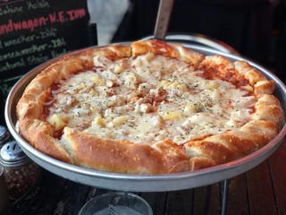 Focused shot of a big pizza with thick crust and cheesy topping