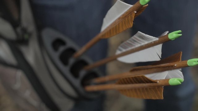 A lady archer pulls her arrow from her quiver, readying for her shot. This clip is part of a series of twelve slow motion clips of her shooting.