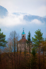 a small church on a hill above idrija in slovenia