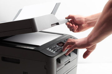 Hand press button on panel of printer. printer scanner laser office copy machine supplies start...