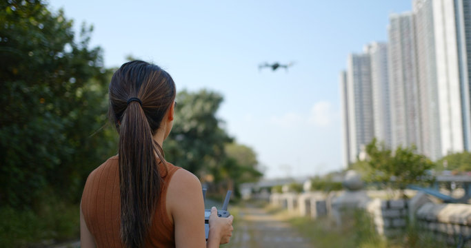 Woman play with flying drone at outdoor
