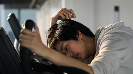 South East Asian woman exhausted from overtraining unhealthy excercise