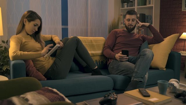 Couple using mobile devices and ignoring each other
