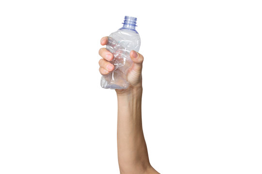 Female hand holds a crumpled plastic bottle on a white isolated background. The concept of separate trash, stop plastic, recycling