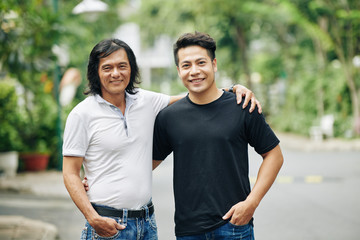 Obraz premium Portrait of happy mature Asian man posing with his handsome adult son