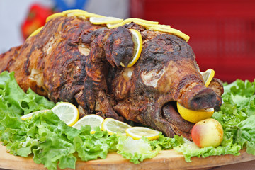 Roast pig. Roasted piglet with vegetables on platter
