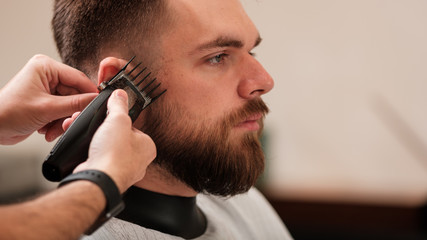 a man haircuts a machine at a hairdresser in a barbershop. shave your head