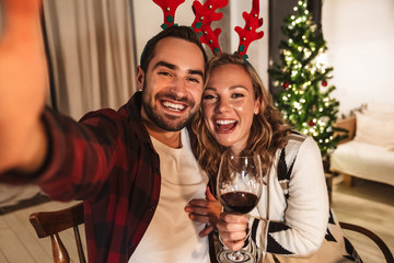 Photo of young smiling couple taking selfie photo and hugging