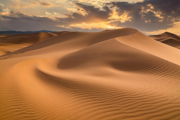 Sunset over the sand dunes in the desert - obrazy, fototapety, plakaty