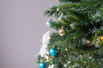 Artificial decorated Christmas tree with balls, ornaments and lights. Festive background for promotion. .