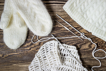 Fototapeta na wymiar Winter background. Knitting, crochet. White mittens and hat.