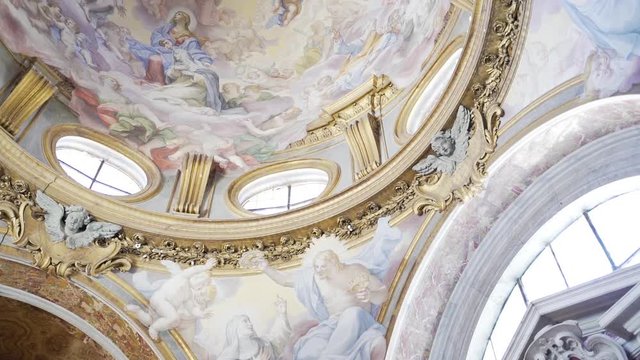Panning past beautiful ceiling artwork inside Roman church