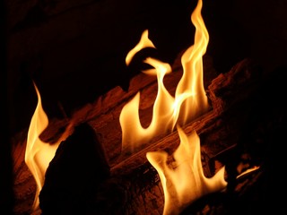Bright orange flames from a fireplace, dark background