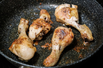the golden chicken legs fried in a frying pan