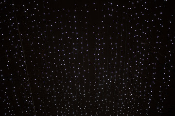 Texture of Christmas lights garlands in blur. Background of holiday lights