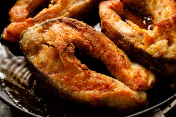 Carp, frying carp divided into portions, breaded in breadcrumbs and flour in a pan, close-up. Christmas Eve dish