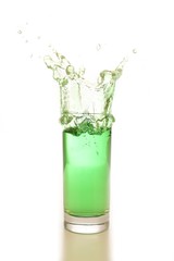 green water or drink splash out of a glass isolated on white background