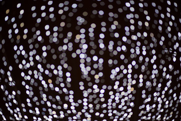 Texture of Christmas lights garlands in blur. Background of holiday lights