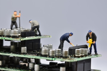 Mini workers are working on a circuit board 