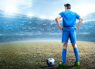 Rear view of Asian football player man standing with the ball