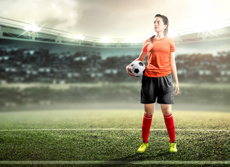 Asian football player woman holding the ball on the football field