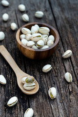 Pistachio nut in wooden bowl on rusty wood table background