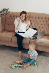 Beautiful business woman working at home. Multi-tasking, freelance and motherhood concept