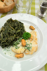 fillet of fish with cream and spinach on a plate