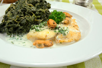 fillet of fish with cream and spinach on a plate