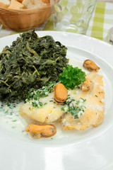 fillet of fish with cream and spinach on a plate