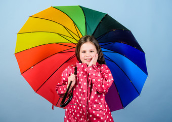 cheerful hipster child in positive mood. autumn fashion. happy small girl with colorful umbrella. rain protection. Rainbow. Small girl in raincoat. Enjoying the most beautiful place