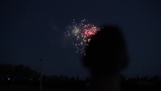 Blurred closeup silhouette of a man enjoying fireworks at night