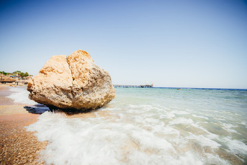 coral beach with a pier, beautiful sea, big Stone.
